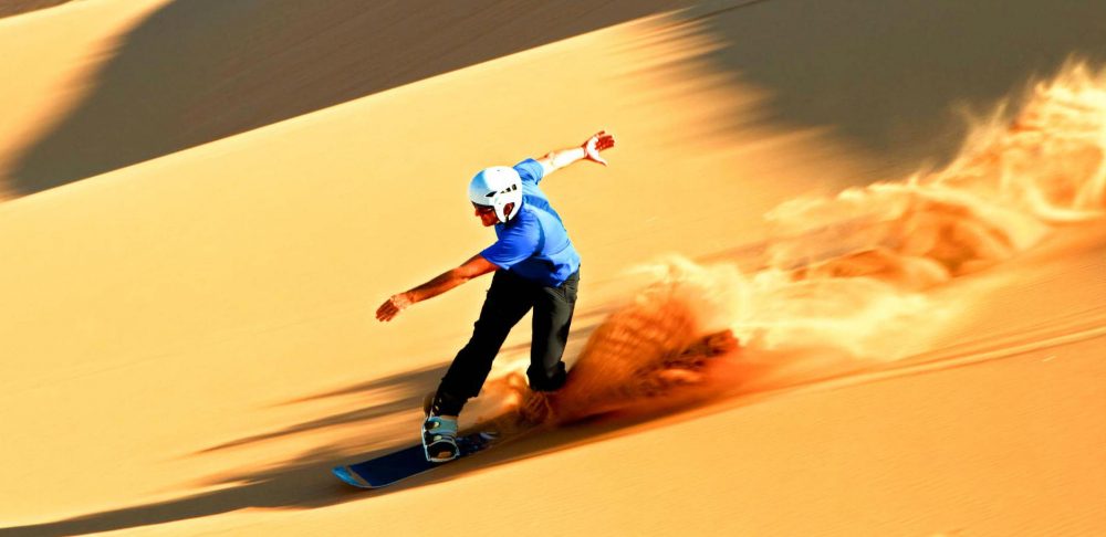 Sand boarding down the slopes