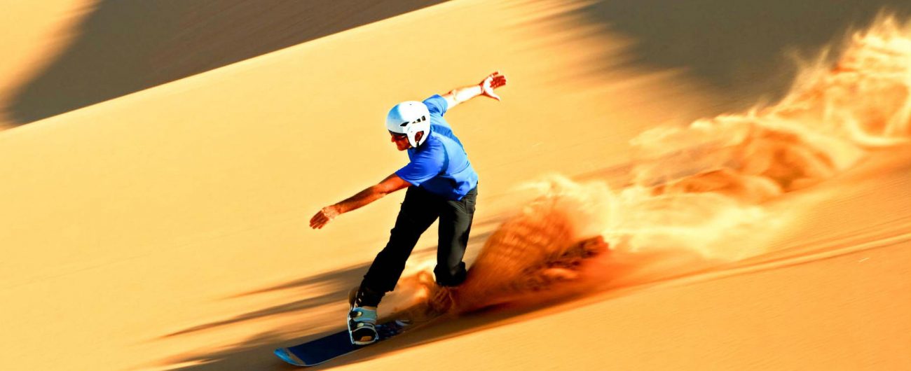 Sand boarding down the slopes