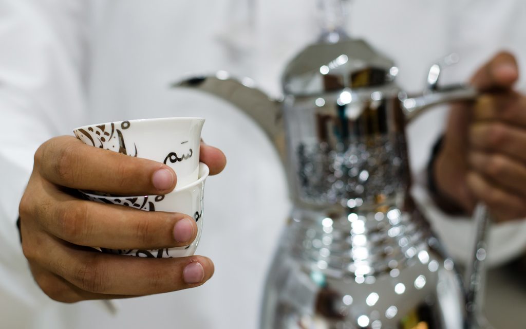 Arab holding coffee cup